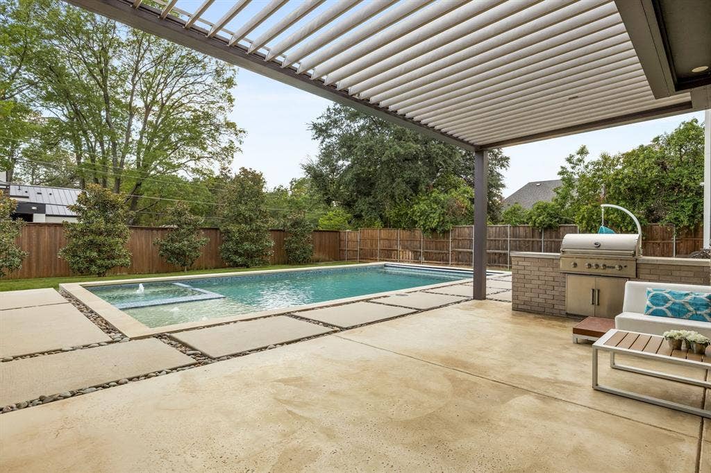 5724 Charlestown Drive, Dallas, TX 75230 Outdoor living space featuring a louvered pergola, built-in BBQ station, swimming pool with integrated spa, and concrete paver patio