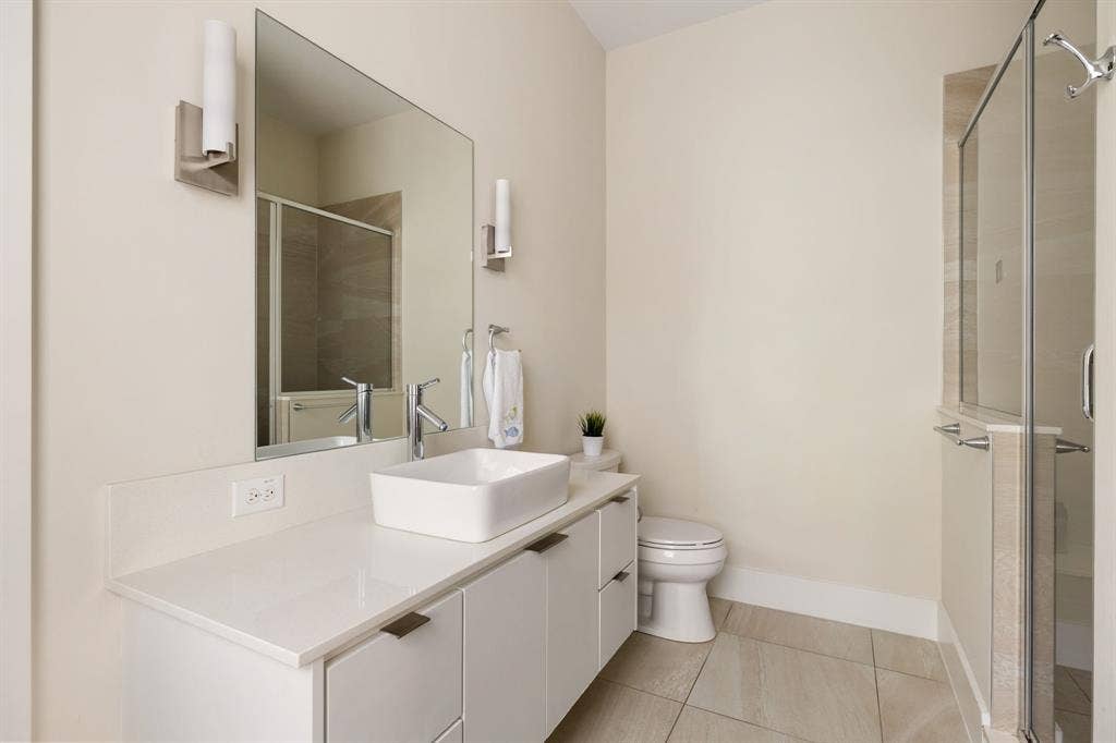 5724 Charlestown Drive, Dallas, TX 75230 White floating vanity with a vessel sink, polished chrome fixtures, and a frameless mirror