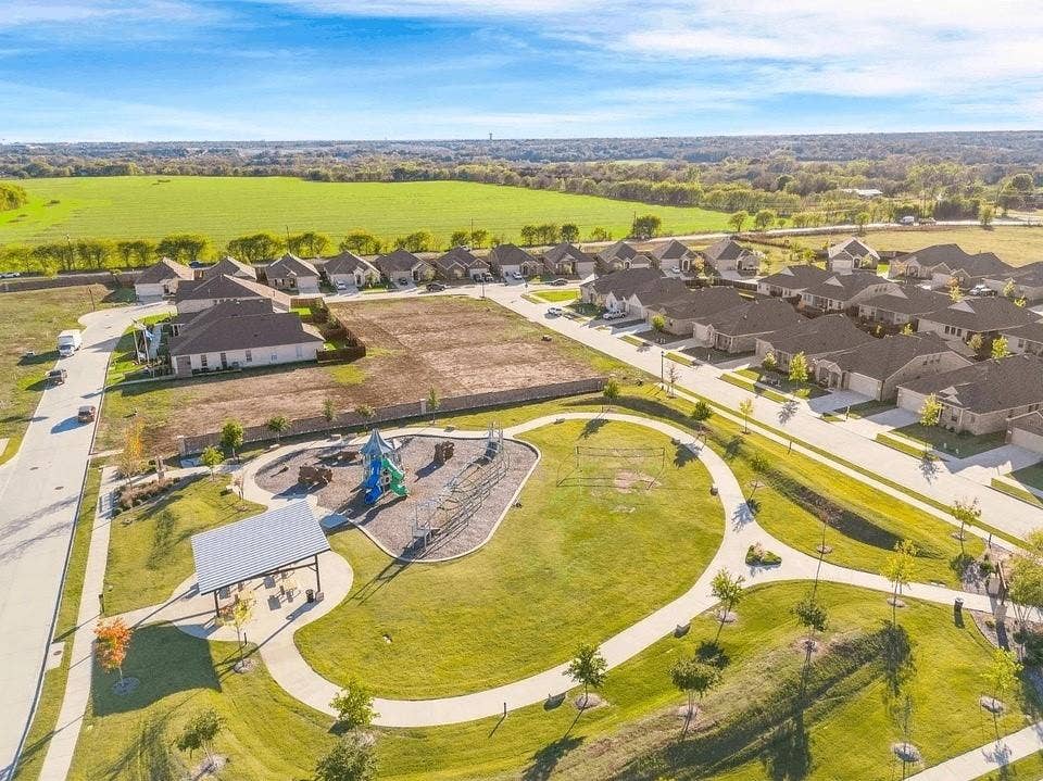 7908 Gilbert Street, McKinney, TX 75071 Expansive community green space with meandering pathways, a children's play area, and a shaded picnic structure
