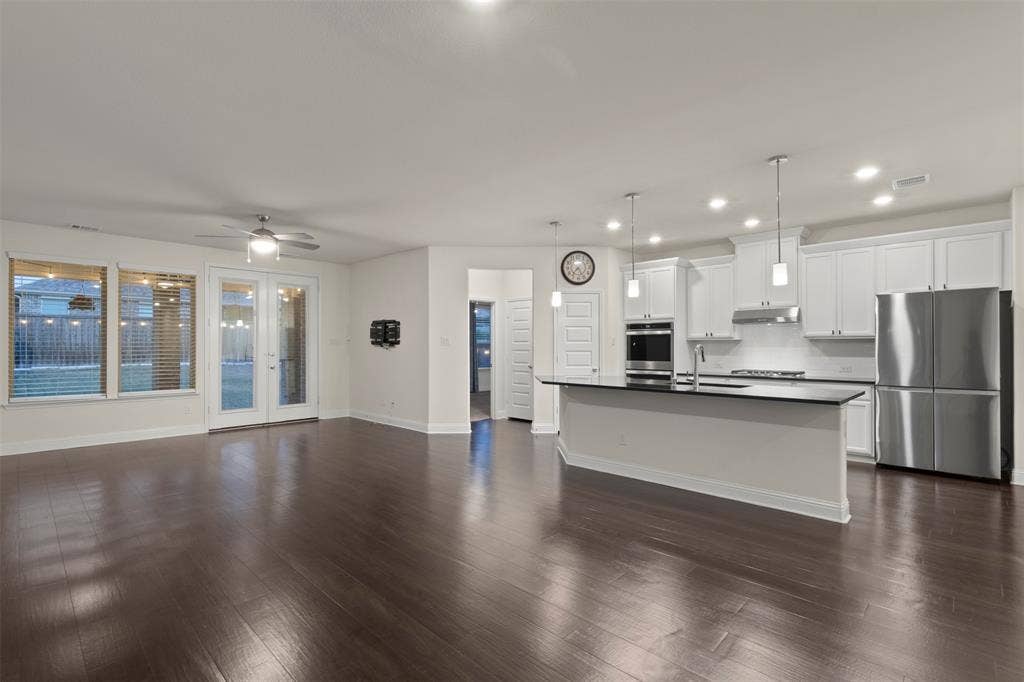 8028 Hickory Branch Drive, Frisco, TX 75034 Hardwood-finish flooring, white cabinetry, stainless steel appliances, kitchen island with dark countertop, and recessed lighting