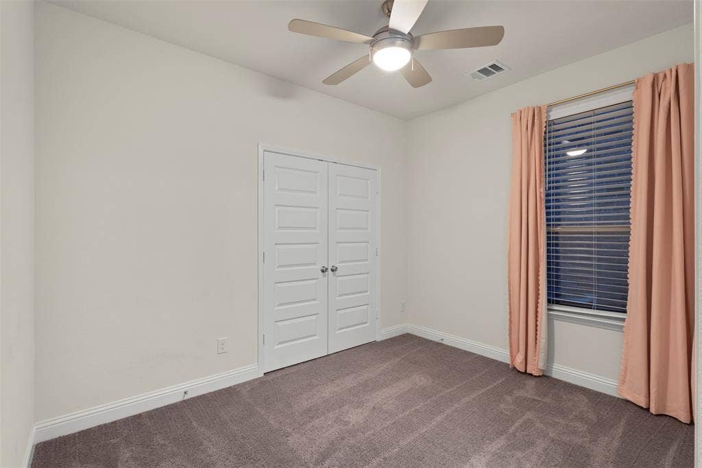 8028 Hickory Branch Drive, Frisco, TX 75034 Neutral wall finishes, textured carpeting, double panel doors, and a ceiling fan with integrated lighting