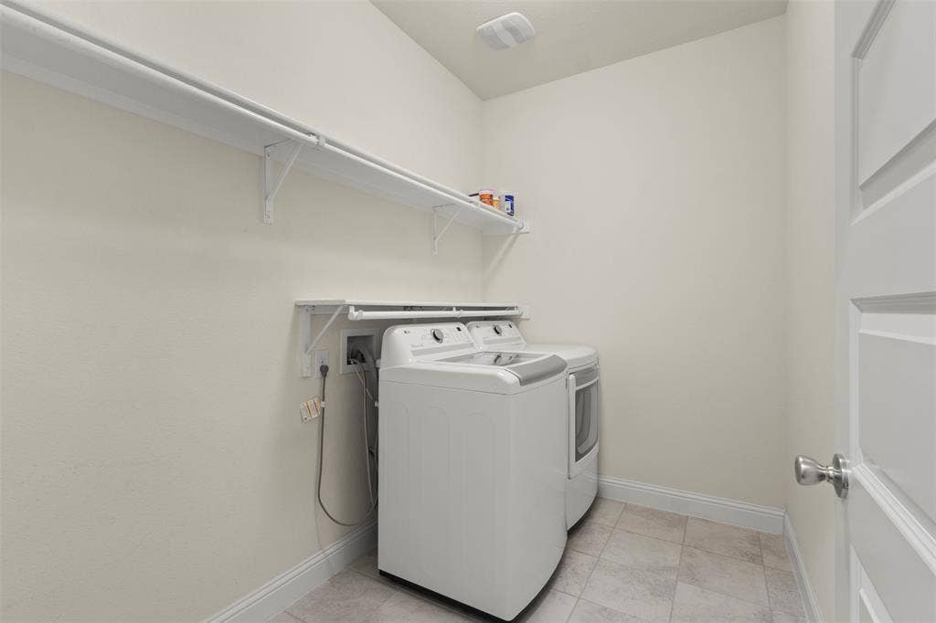 8028 Hickory Branch Drive, Frisco, TX 75034 Laundry area with a built-in shelving system, tiled flooring, and a paneled door