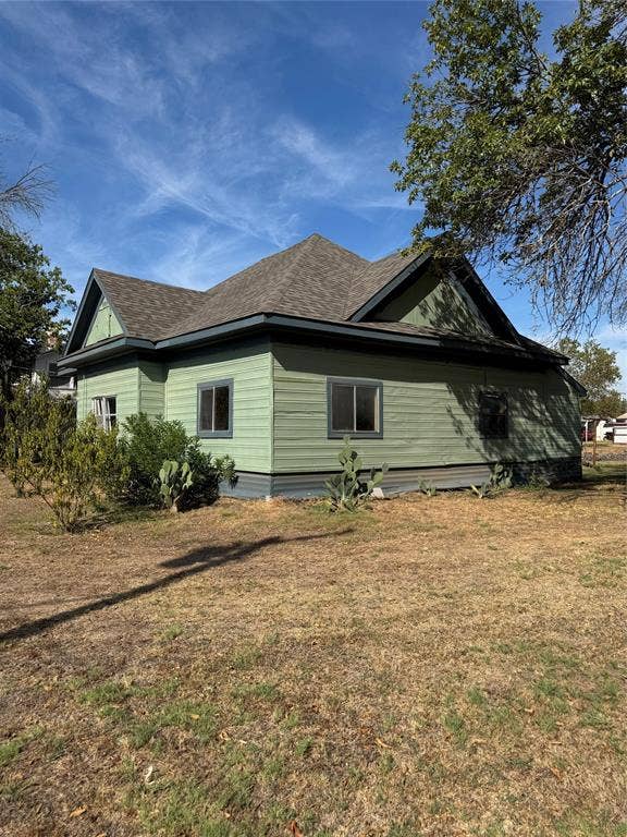 102 N 6th Street W, Dawson, TX 76639 Green exterior siding with contrasting trim, multiple windows, and a shingle roof