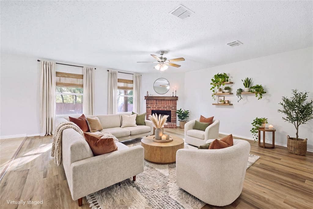 Hard-surface flooring, brick fireplace, ceiling fan, multiple windows, and recessed lighting