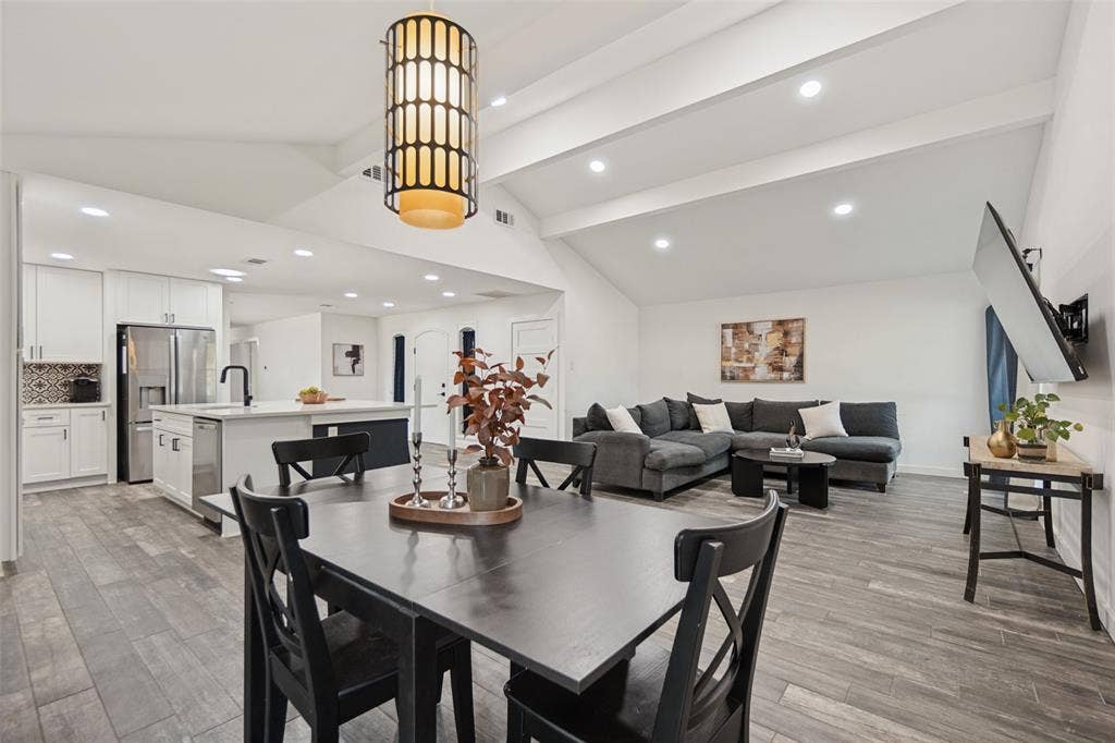 9038 Flicker Lane, Dallas, TX 75238 Vaulted ceilings with exposed beams, wood-finish flooring, recessed lighting, and a modern kitchen island with an undermount sink