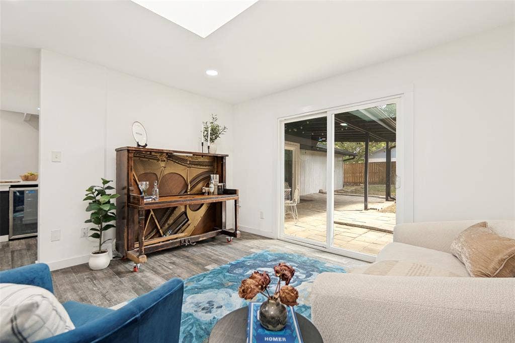 9038 Flicker Lane, Dallas, TX 75238 Recessed lighting, skylight, wood-finish flooring, sliding glass door, and a paved outdoor patio
