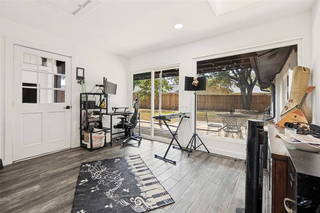 9038 Flicker Lane, Dallas, TX 75238 Wood-finish flooring, white paneled French door, large sliding glass door, white walls, and recessed lighting