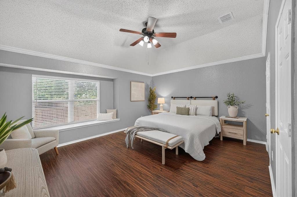 Vaulted ceiling with a central multi-light ceiling fan, integrated window seat, and wood-finish flooring