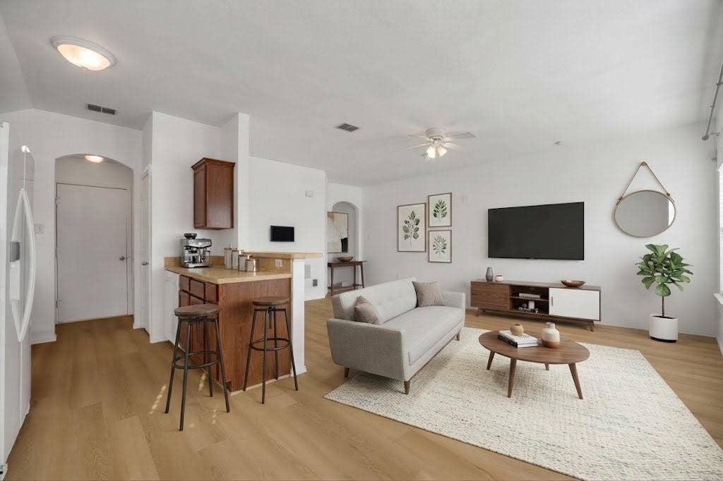 Wood-finish flooring throughout, white walls, and an arched doorway