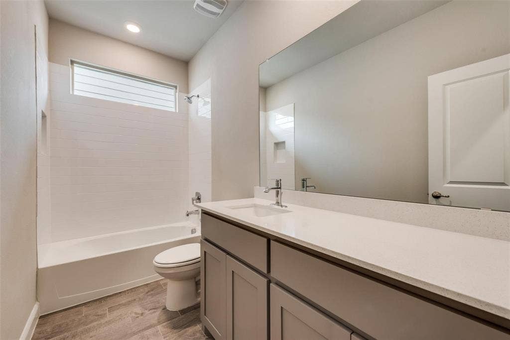 2441 Bellatrix Drive, Haslet, TX 76052 Full bathroom featuring bathing tub / shower combination, toilet, vanity, and wood-type flooring