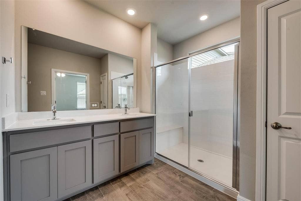 2441 Bellatrix Drive, Haslet, TX 76052 Bathroom featuring dual vanity, a shower with shower door, and wood-type flooring