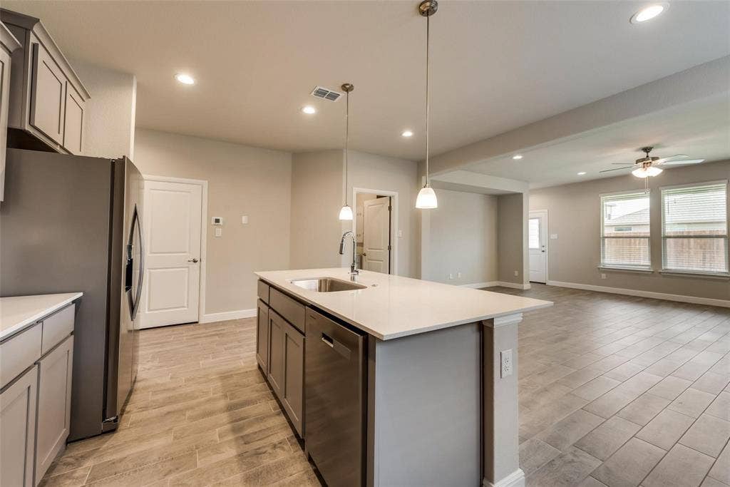 2441 Bellatrix Drive, Haslet, TX 76052 Kitchen featuring appliances with stainless steel finishes, gray cabinetry, sink, hanging light fixtures, and ceiling fan