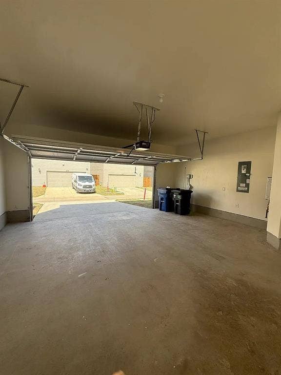 Attached garage with concrete flooring and an automatic garage door opener