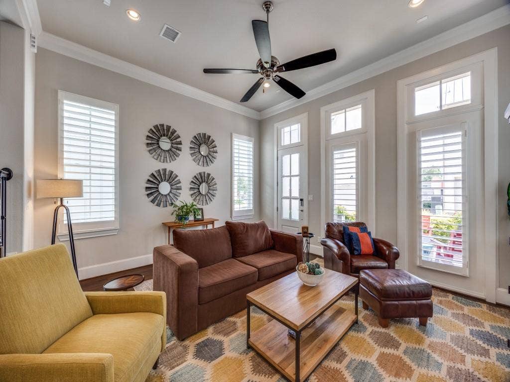 Recessed lighting, crown molding, ceiling fan, multiple windows with plantation shutters, and wood-finish flooring
