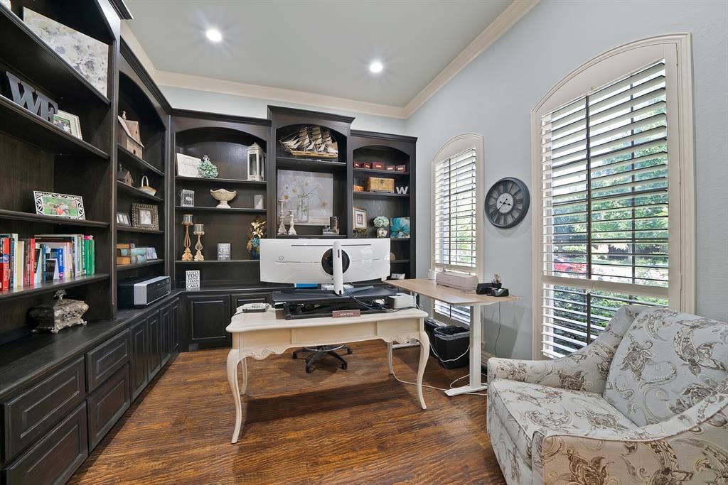 A beautifully appointed home office features custom built-ins and a desirable location at the front of the home, creating a private and convenient space for working from home.