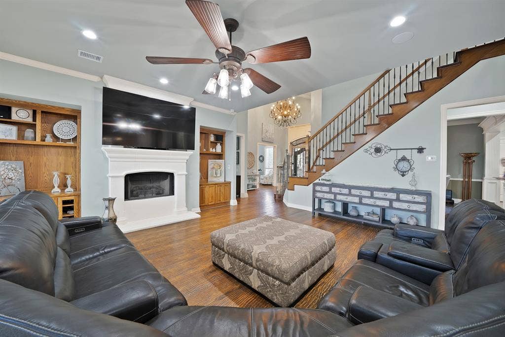 A warm and inviting living space creates the perfect setting for gatherings, complemented by a wall of windows that fills the room with natural light and offers beautiful views of the outdoors.