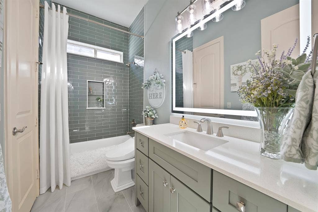 A beautifully updated guest bathroom, reminiscent of a luxury magazine spread, is thoughtfully located just off the kitchen and features stylish finishes that elevate both form and function.