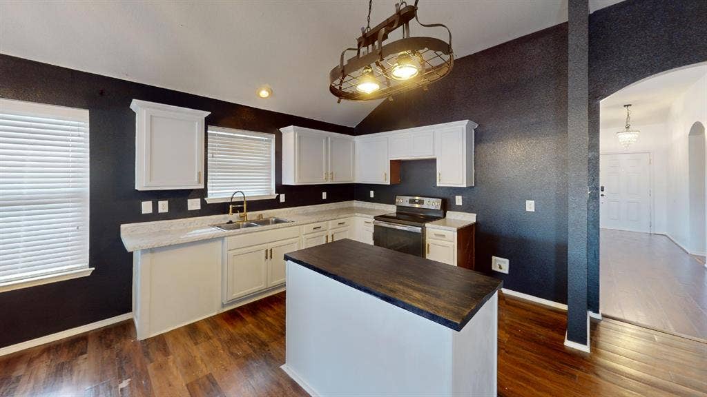 1815 Shanna Drive, Lancaster, TX 75134 Kitchen featuring white cabinetry, a central island with a wood-finish countertop, wood-finish flooring, and a stainless steel range