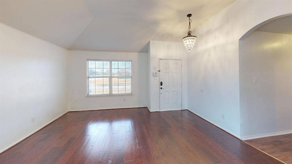 1815 Shanna Drive, Lancaster, TX 75134 Rich wood-finish flooring, a decorative chandelier, and an arched entry
