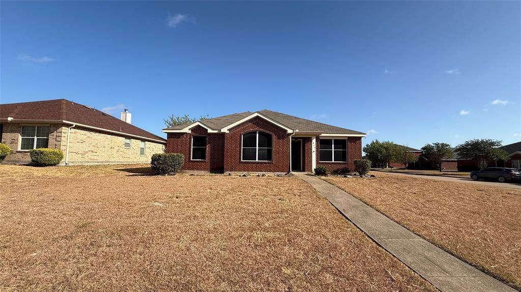 1815 Shanna Drive, Lancaster, TX 75134 Red brick exterior with arched windows, a covered entry, and a concrete pathway