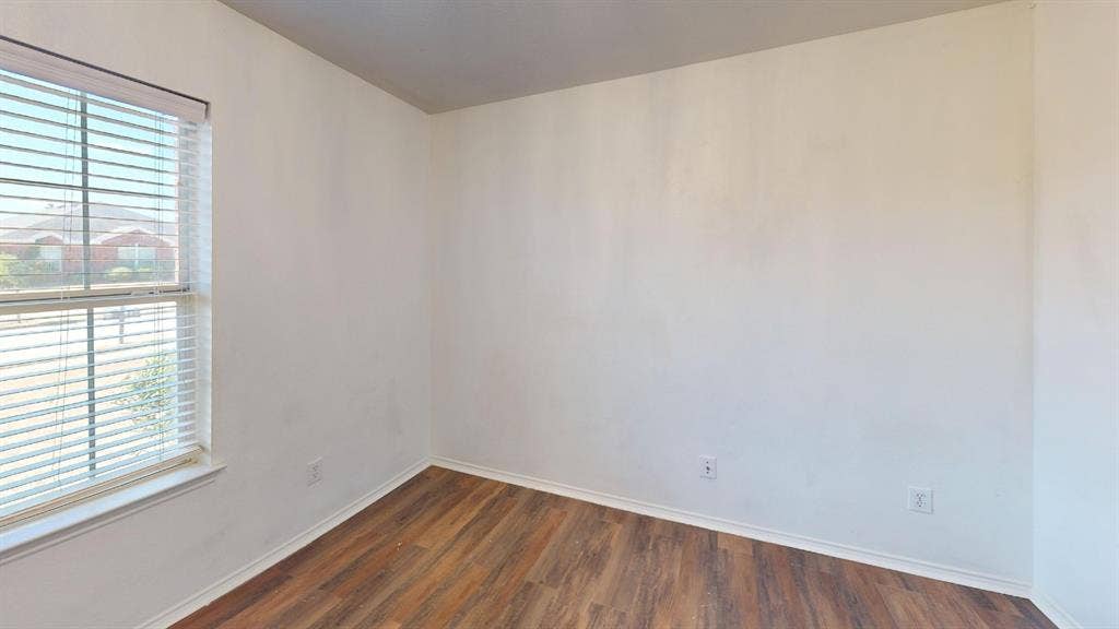 1815 Shanna Drive, Lancaster, TX 75134 Wood-finish flooring with white baseboards, bright white walls, and a window with blinds