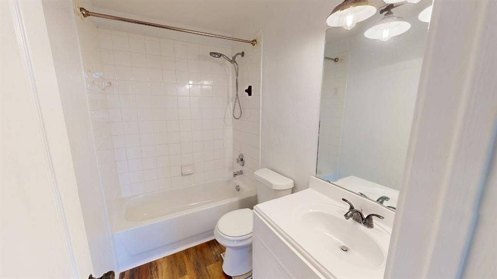 1815 Shanna Drive, Lancaster, TX 75134 White tiled shower surround, bathtub, toilet, vanity with integrated sink, and overhead light fixture