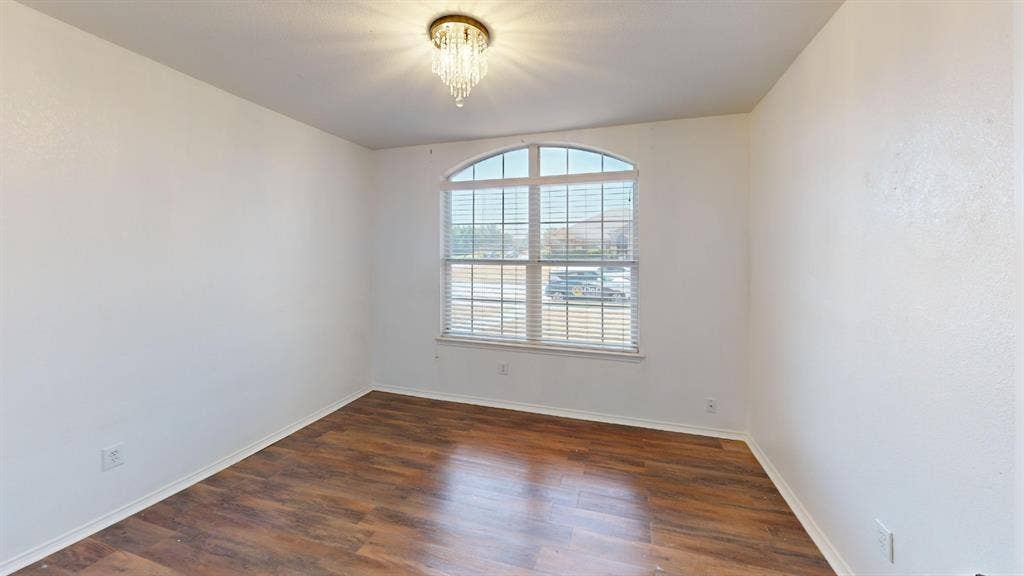 1815 Shanna Drive, Lancaster, TX 75134 Arch-top window with horizontal blinds, wood-finish flooring, and a crystal flush mount light fixture