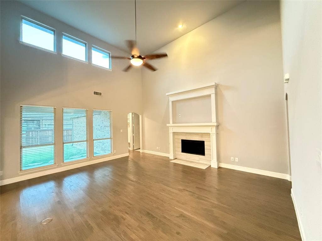 11818 Antler Drive, Frisco, TX 75035 Vaulted ceiling, wood-finish flooring, built-in fireplace, ceiling fan with integrated lighting, and multiple windows