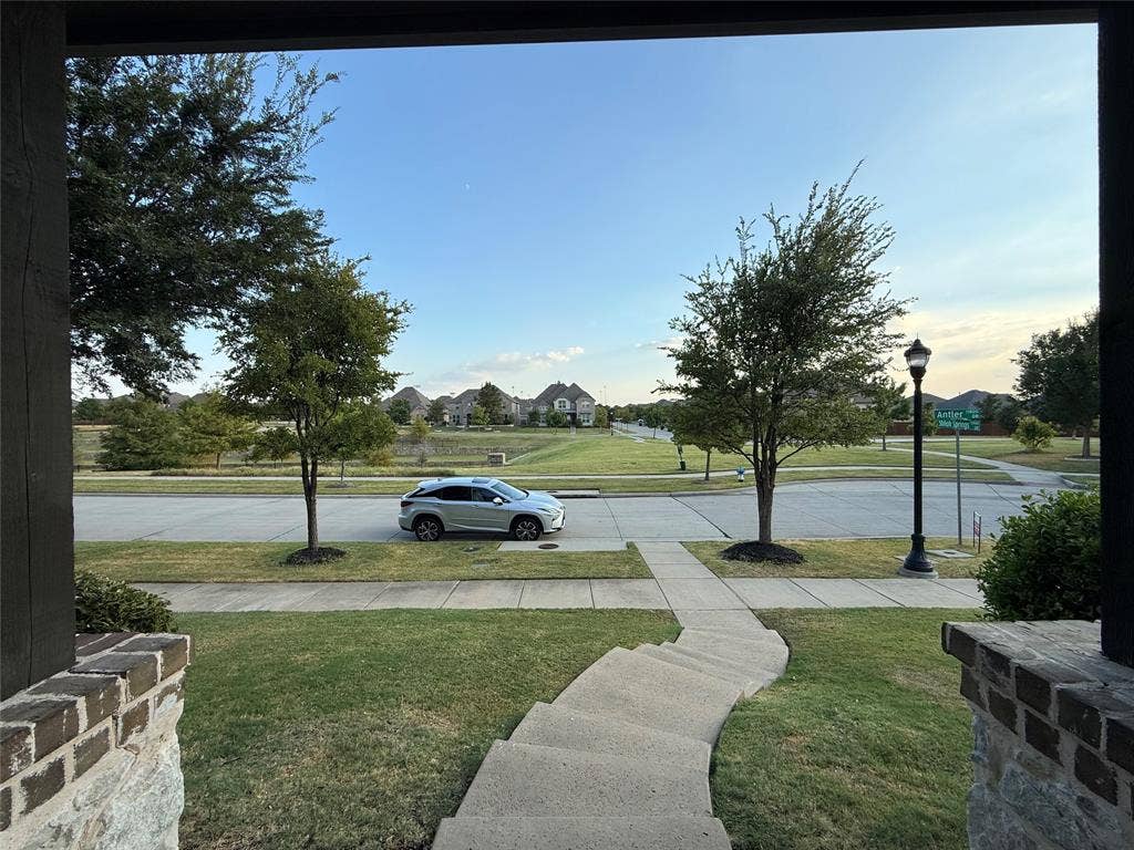 11818 Antler Drive, Frisco, TX 75035 Brick and stone exterior detailing, concrete walkway, established front yard landscaping, street light fixture, paved street access