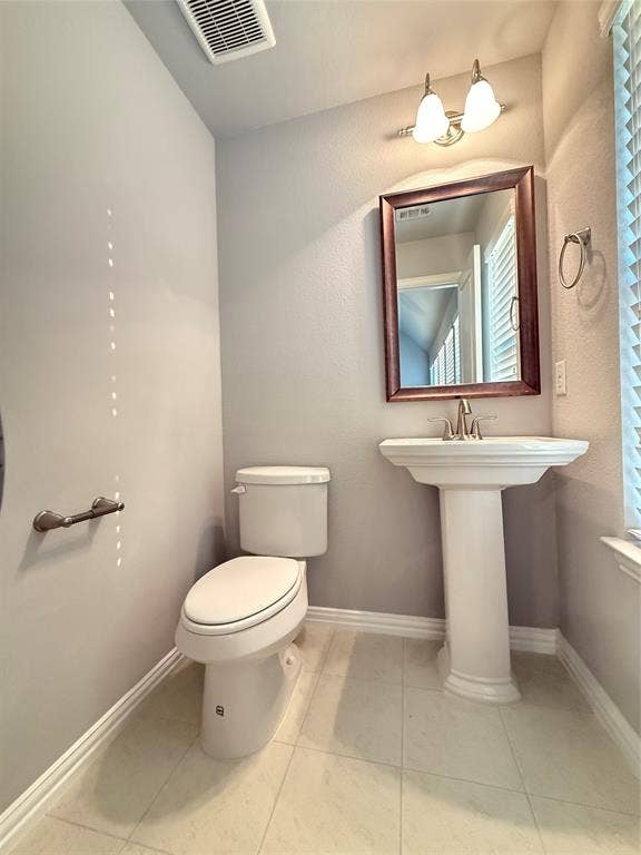 11818 Antler Drive, Frisco, TX 75035 Pedestal sink with polished chrome faucet, framed mirror, and dual-bulb vanity light