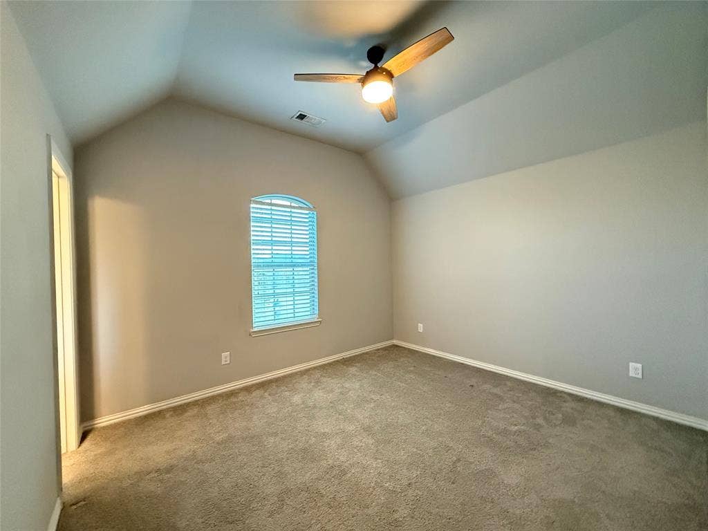 11818 Antler Drive, Frisco, TX 75035 Vaulted ceiling with an attached ceiling fan, arched window with horizontal blinds, and neutral-toned carpeting