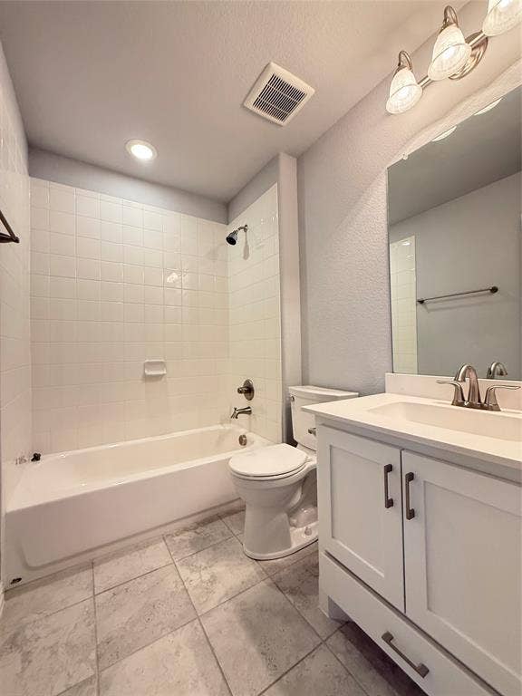 11818 Antler Drive, Frisco, TX 75035 White subway tile surround, tile flooring, white vanity with shaker-style cabinetry, chrome faucet, and three-light vanity fixture