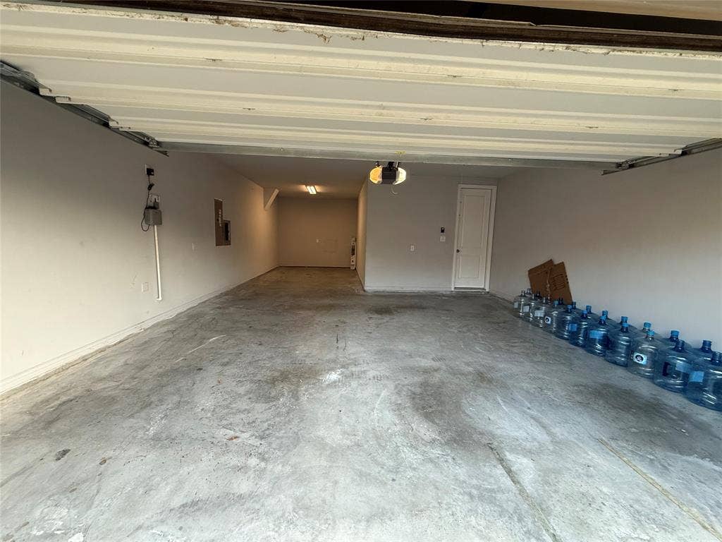 11818 Antler Drive, Frisco, TX 75035 Spacious garage with concrete flooring, painted walls, and a built-in overhead garage door opener