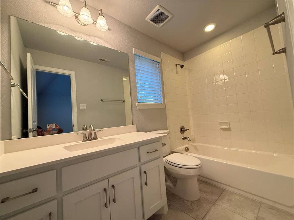 11818 Antler Drive, Frisco, TX 75035 White vanity with an integrated sink, brushed nickel faucet, large mirror, and tiled flooring