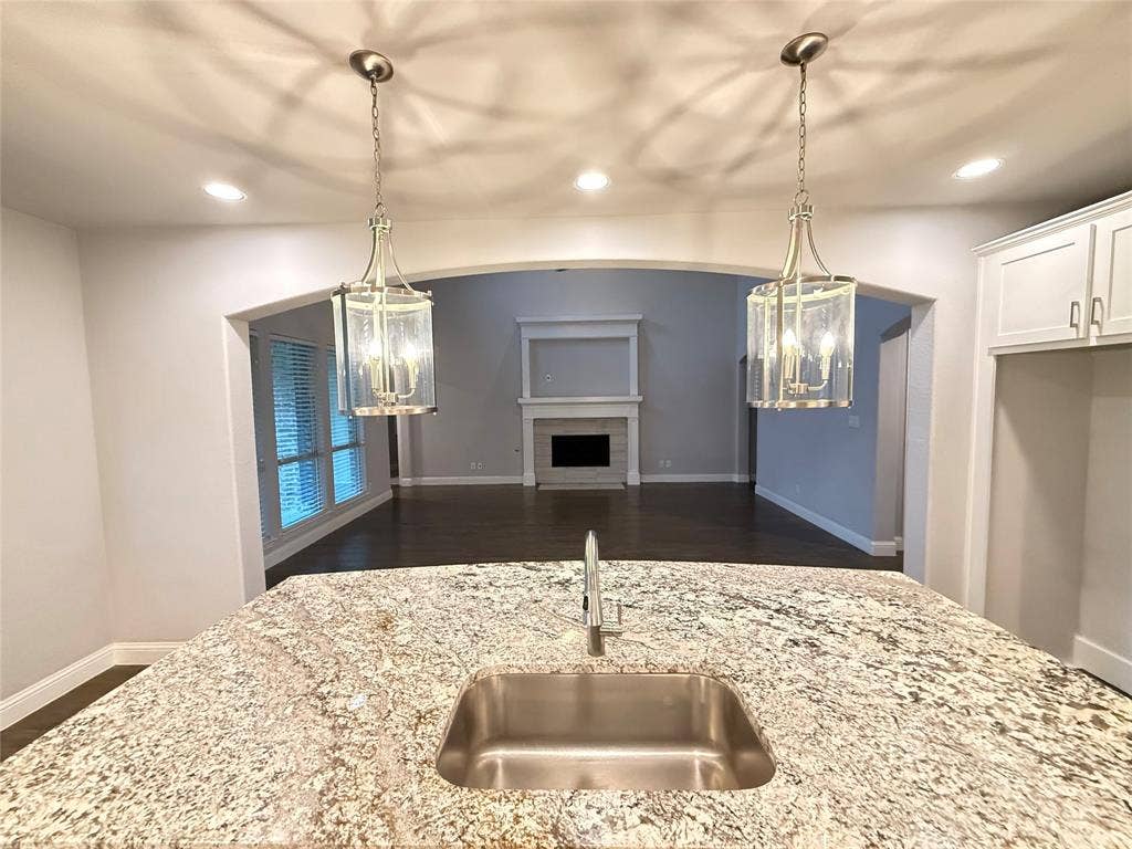 11818 Antler Drive, Frisco, TX 75035 Kitchen island featuring a stainless steel sink and speckled countertop
