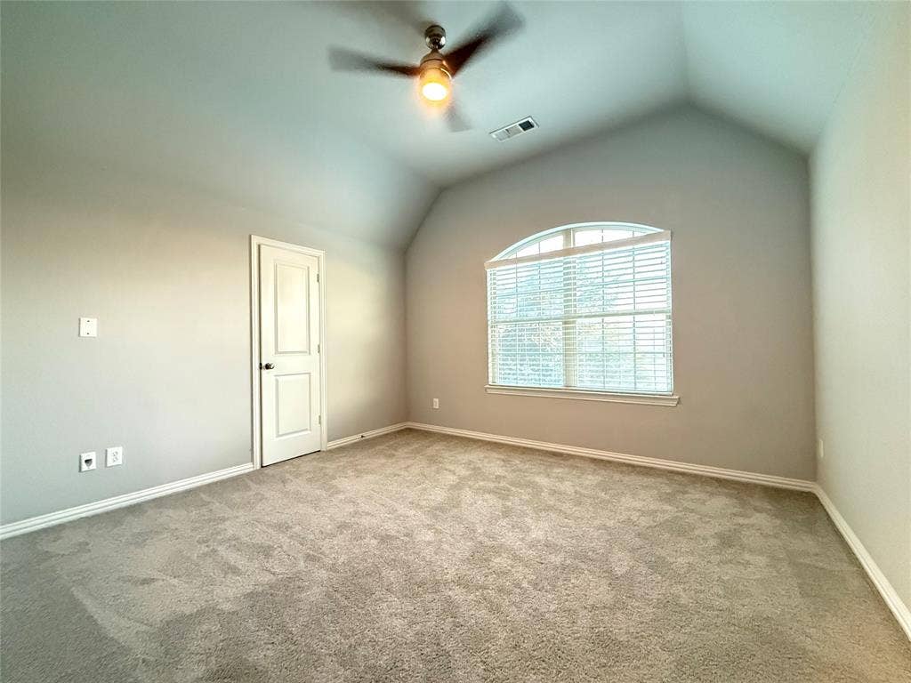 11818 Antler Drive, Frisco, TX 75035 Vaulted ceiling with an arched window, ceiling fan, neutral wall paint, and light-colored carpet flooring