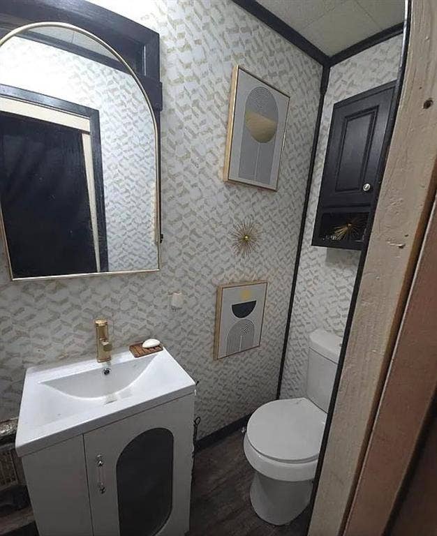 6220 W Highway 199, Springtown, TX 76082 Vanity with integrated sink, gold-finish faucet, wall-mounted mirror, and patterned wallpaper