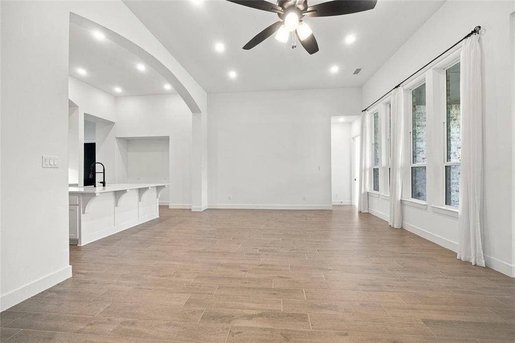 Wood-finish flooring, recessed lighting, and a ceiling fan