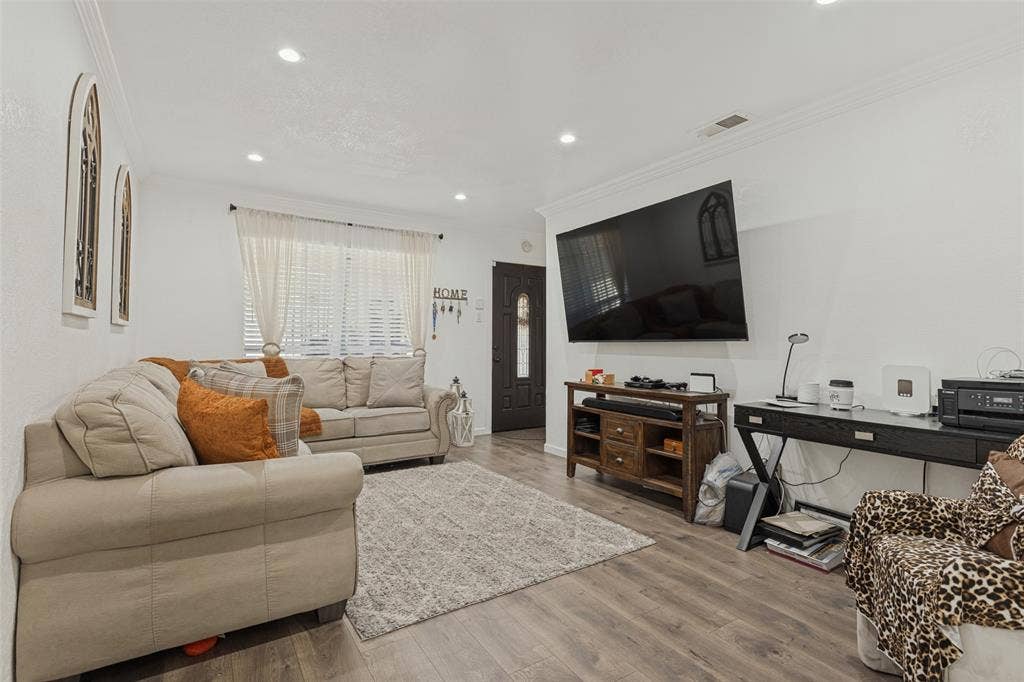 1522 Carroll Drive, Garland, TX 75041 Living area featuring wood-finish flooring, recessed lighting, crown molding, and a paneled entry door