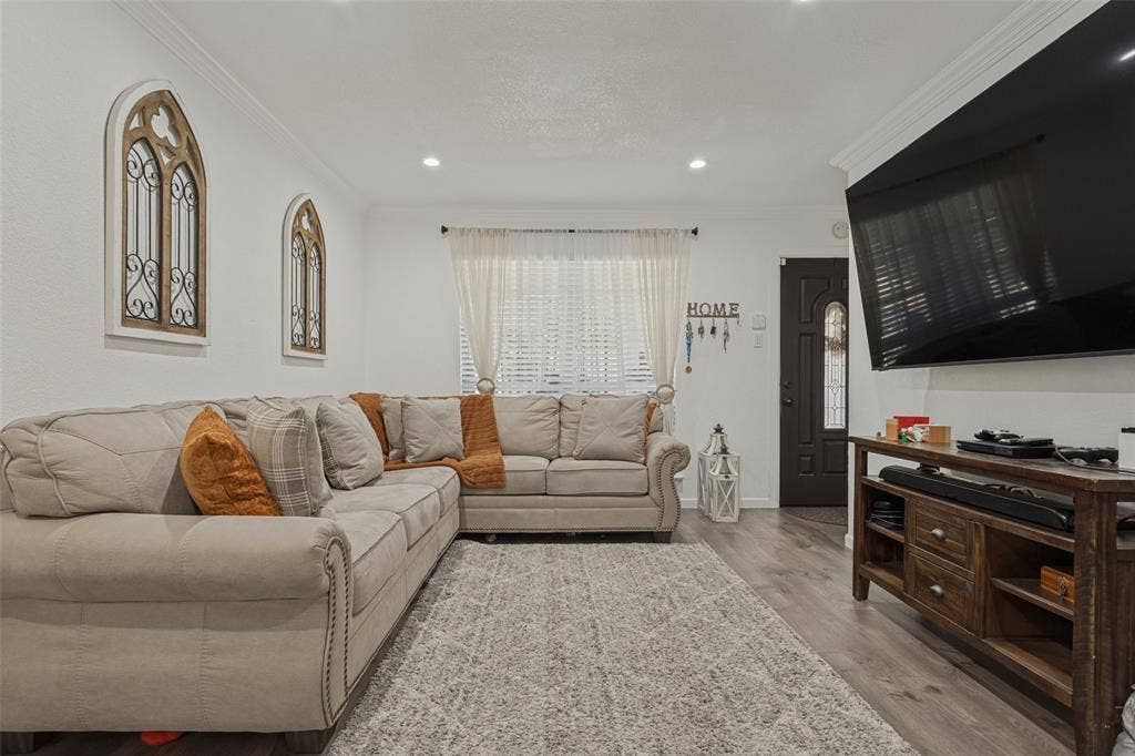 1522 Carroll Drive, Garland, TX 75041 Living space featuring wood-finish flooring, recessed lighting, crown molding, and a dark-toned entry door with decorative glass paneling