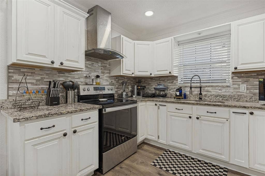 1522 Carroll Drive, Garland, TX 75041 Kitchen featuring white shaker-style cabinetry, stone-finish countertops, linear mosaic tile backsplash, stainless steel range with overhead chimney vent, and wood-finish flooring