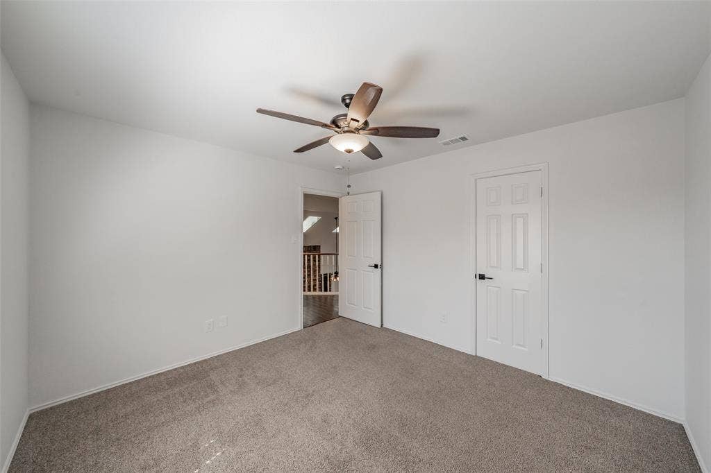 617 Dover Court, Coppell, TX 75019 Secondary bedroom with carpet, ceiling fan, and walk in closet