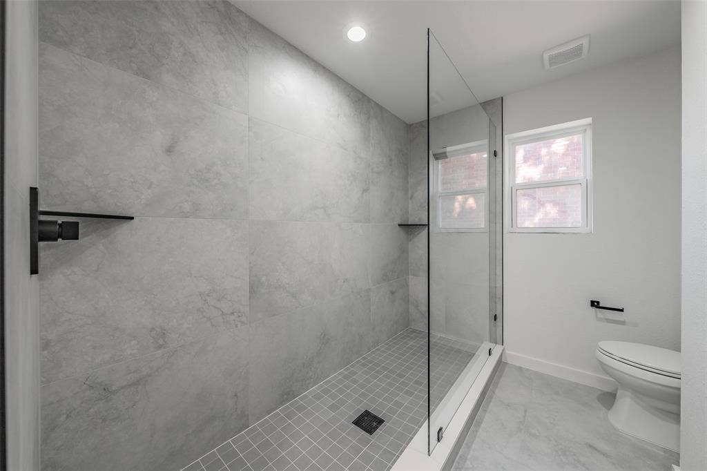 617 Dover Court, Coppell, TX 75019 Glass-enclosed oversized shower with large format wall tiles, a built-in shower niche, and a tiled floor