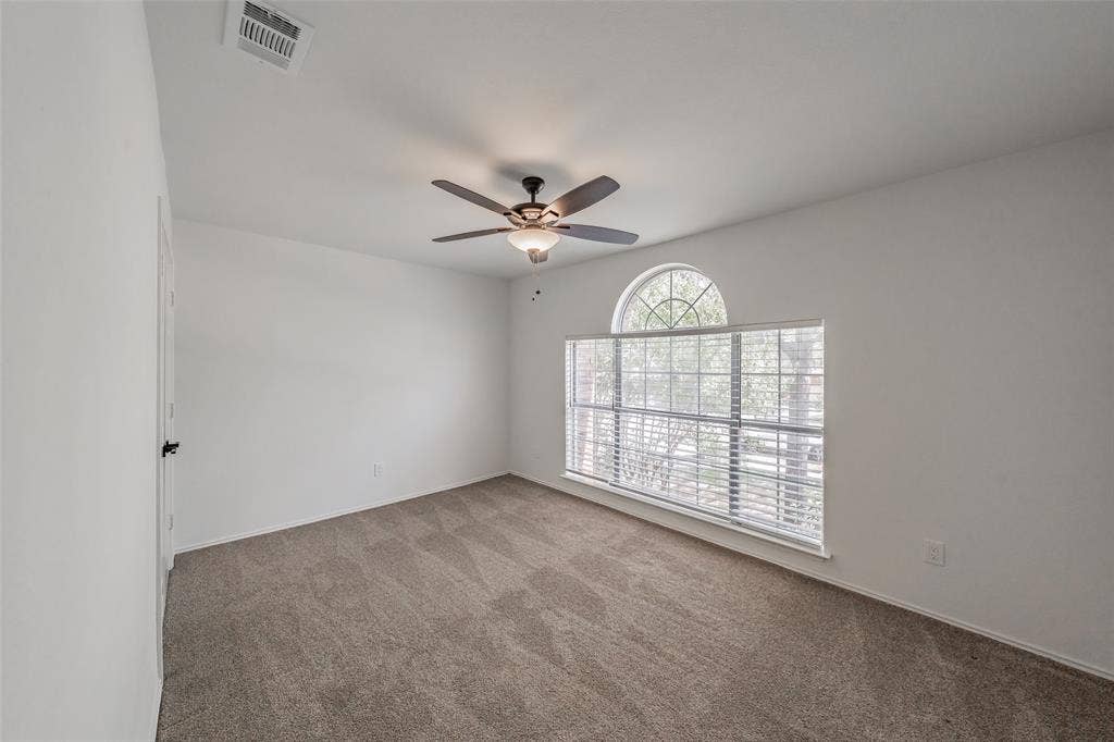 617 Dover Court, Coppell, TX 75019 Third bedroom has large window with arched transom, carpet, ceiling fan with integrated lighting, and closet