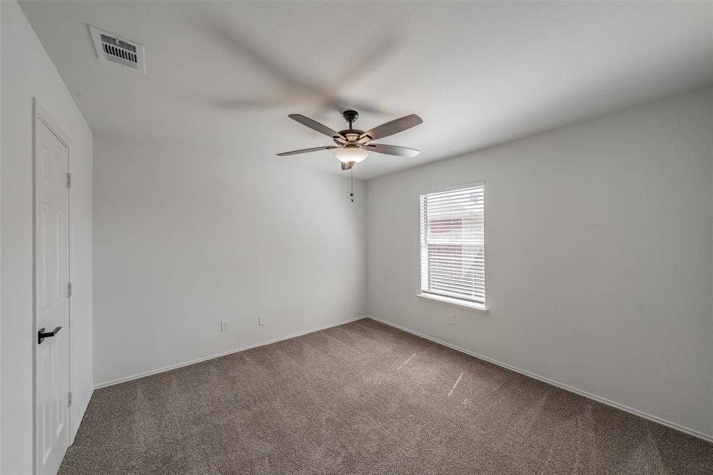 617 Dover Court, Coppell, TX 75019 Secondary bedroom with carpet, ceiling fan, and walk in closet