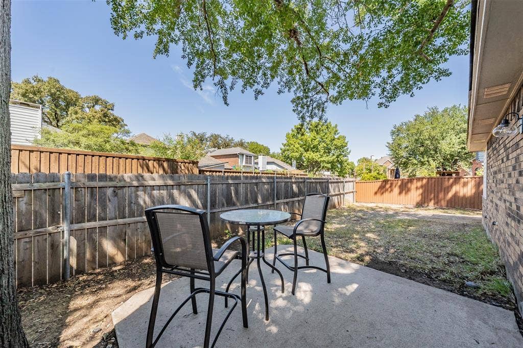 617 Dover Court, Coppell, TX 75019 Expansive backyard featuring a concrete patio, wood privacy fencing, and mature trees