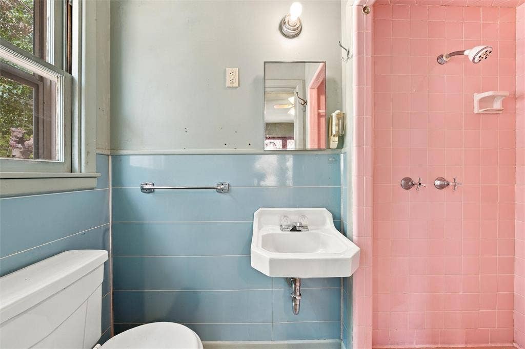 2725 Morrow Avenue, Waco, TX 76707 Bathroom featuring a pedestal sink, wall-mounted mirror, overhead lighting, and a shower with tile surround