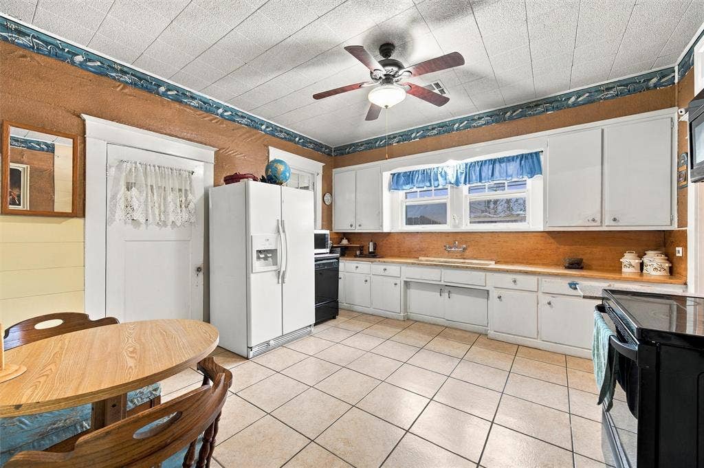 2725 Morrow Avenue, Waco, TX 76707 Kitchen featuring tile flooring, white cabinetry, a built-in ceiling fan, and wood-finish countertops