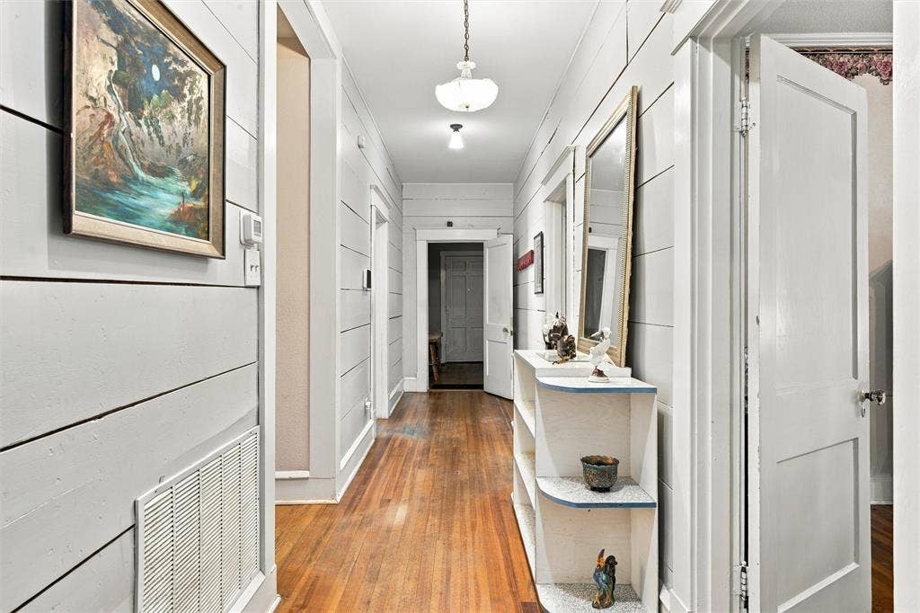 2725 Morrow Avenue, Waco, TX 76707 Hardwood flooring throughout, shiplap wall paneling, built-in shelving unit, interior doors, and ceiling-mounted light fixtures