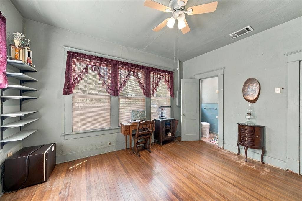 2725 Morrow Avenue, Waco, TX 76707 Hardwood flooring throughout, multiple windows, built-in shelving, ceiling fan, and a light-colored painted wall finish